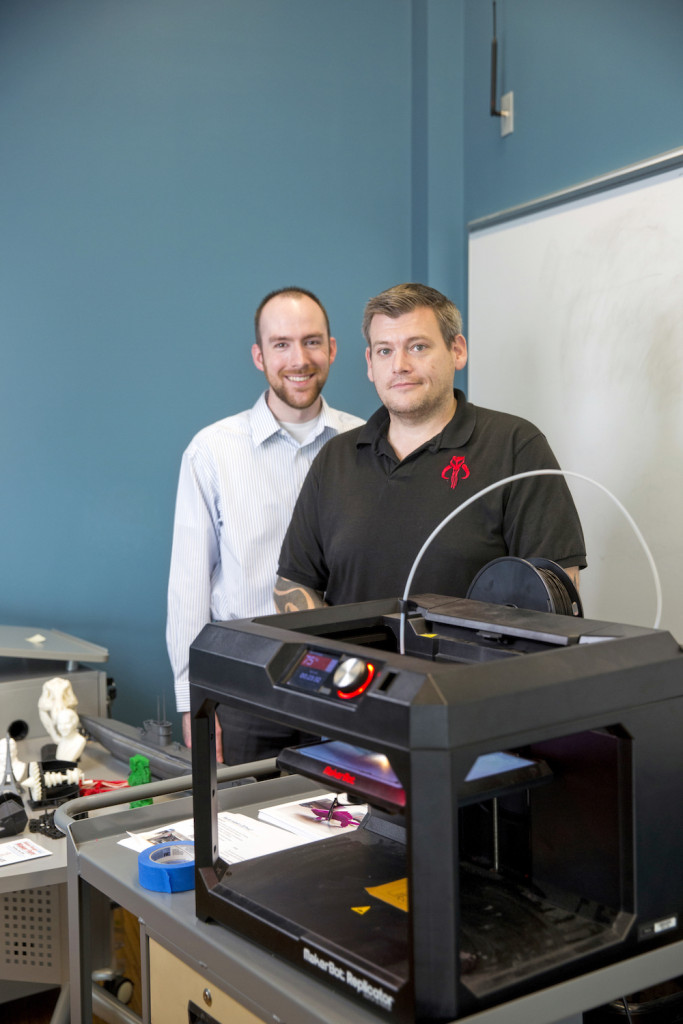 From left, digital librarian Bryce Tomlin and technology engineer Michael Brandyberry show what the 3-D printer can do. “I sort of understand now how my parents felt about computers when they first came out,” Brandyberry says, “because I saw this and I went, ‘This is amazing. I’m jumping all over this.’”