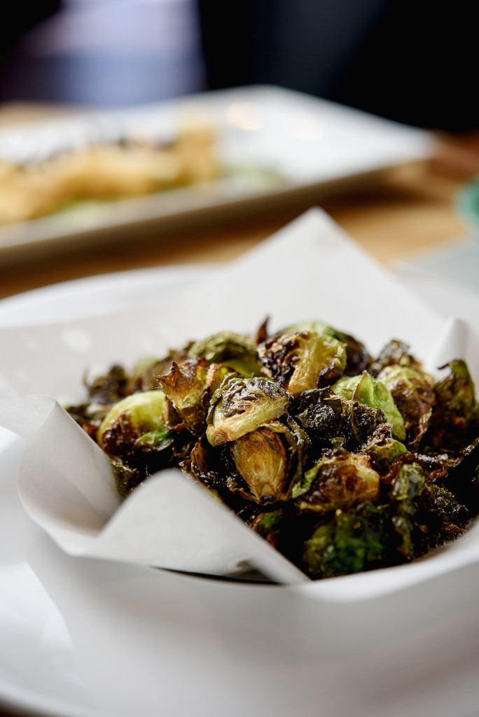 Charred and crispy Brussels sprouts are paired with a tangy chili sauce for a surprising appetizer.