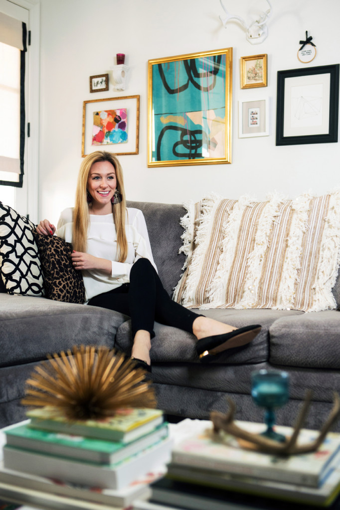 A gallery wall above the sofa features Faircloth’s own paintings, including an abstract turquoise piece and a canvas she used as a palette when she was painting. “It wasn’t supposed to be a painting,” she says of the palette. “But it dried, and I liked it, so I hung it up.” The wall also includes photo booth pictures of her and her husband, a vintage Moulin Rouge drawing she got during a trip to Paris, an embroidery hoop with a Friday Night Lights quote and a geometric print. Mixed in with the art is a pair of deer antlers her grandfather gave her that she painted white.