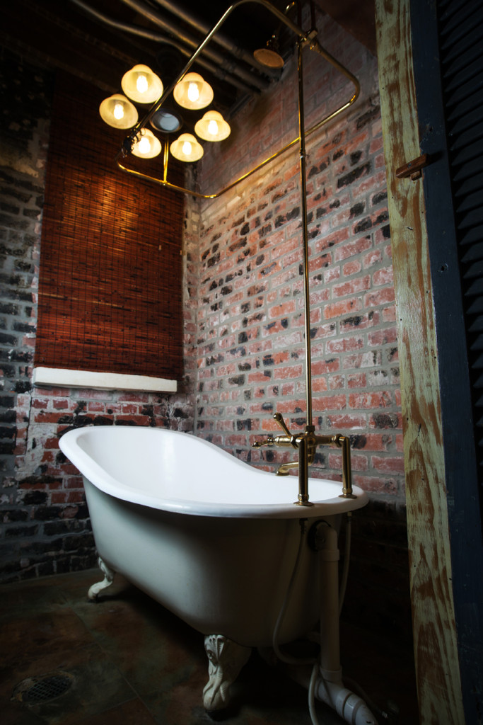 The guest bathroom features a clawfoot tub with a brass faucet and shower enclosure.