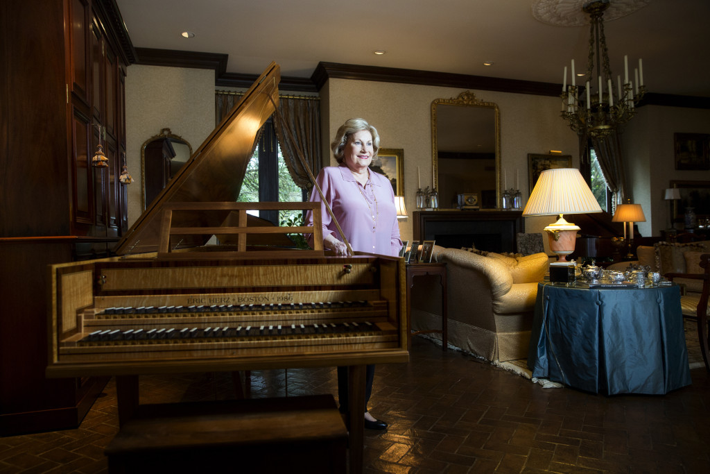 Beth Fuller stands in her home with her prized German double harpsichord.