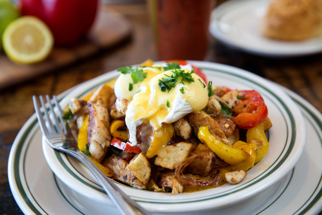 The Farmhouse Hash is a brimming bowl of potatoes, peppers, onions, rotisserie chicken, poached eggs and hollandaise.