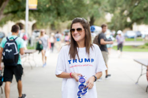 Victoria Chustz, a 22-year-old LSU student studying marketing, political science and business, hands out campaign stickers for Tigers for Trump. Photo by Collin Richie.