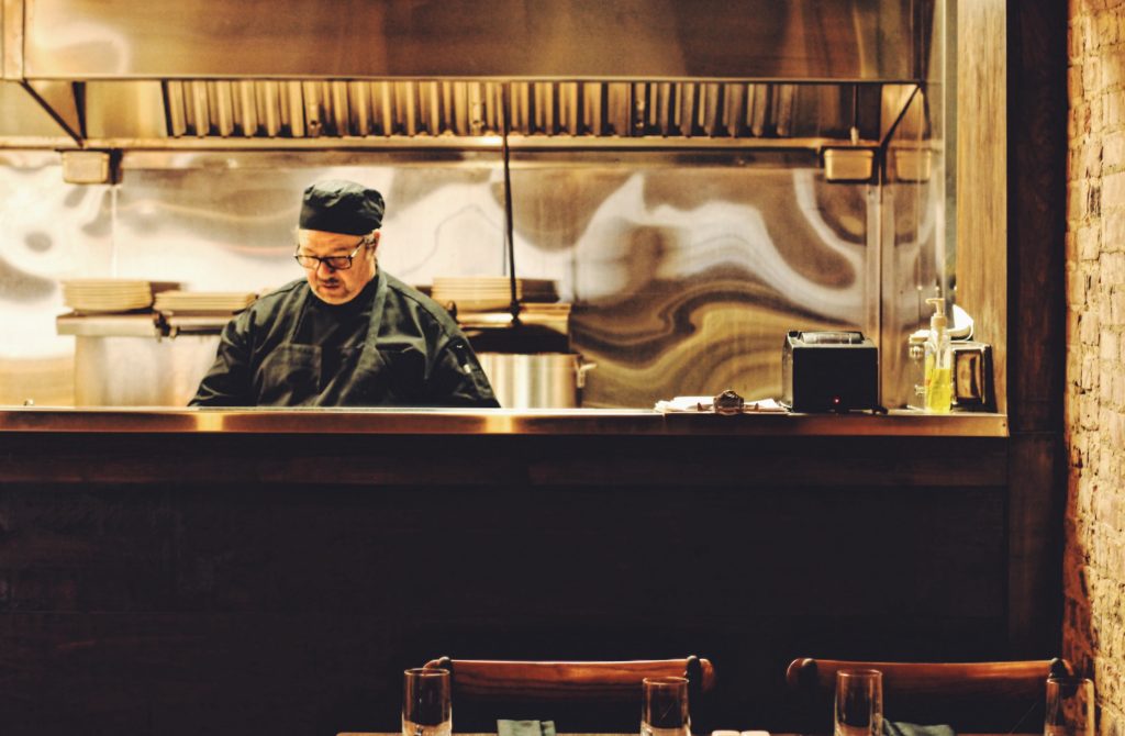 A member of the kitchen staff works in the open kitchen at Cocha during the lunch hour.