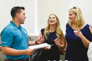 Joseph Tucker with Hydra- Guard Recharge speaks to guests Erica Sweeney (left) and Christy Chachere (right)