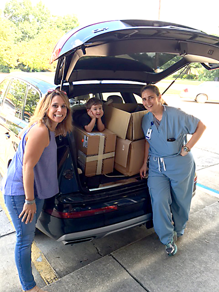 Michelle Forte and Ashley Saucier, with help from Saucier’s son Jibby, loaded up vehicles with donated shoes right after the flood. Photo by Jeannie Frey Rhodes.
